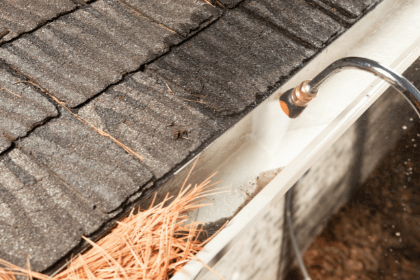 a rain gutter is being cleaned with a pressure washer nozzle